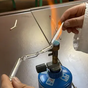 Im Chemieunterricht wird ein Glasrohr über der Flamme eines Gasbrenners gebogen
