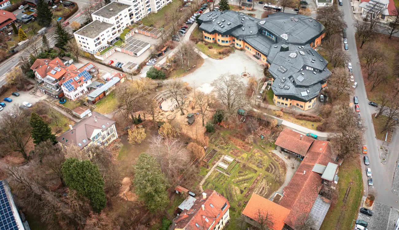 Luftaufnahme von Schulgebäude, Schulhof und den Beeten des Schulgartens