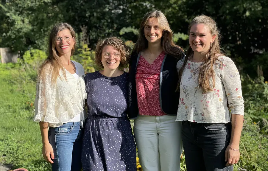 Vier Lehrerinnen stehen lächelnd nebeneinander im Garten